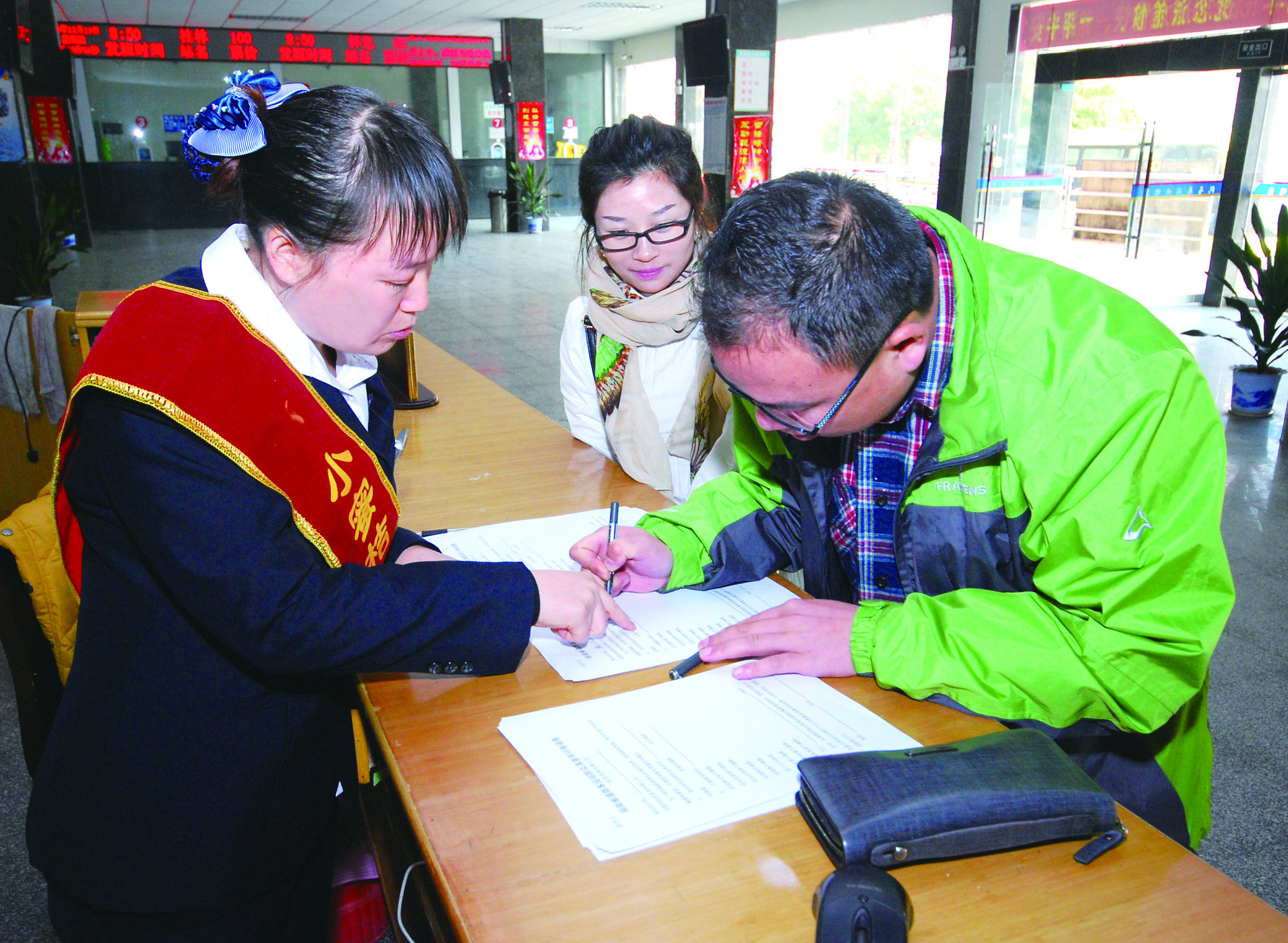 圖為洞口汽車(chē)總站站務(wù)人員在熱心為旅客服務(wù)。